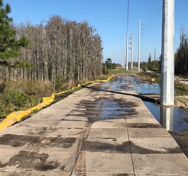 Portable roadway mats over muddy ground