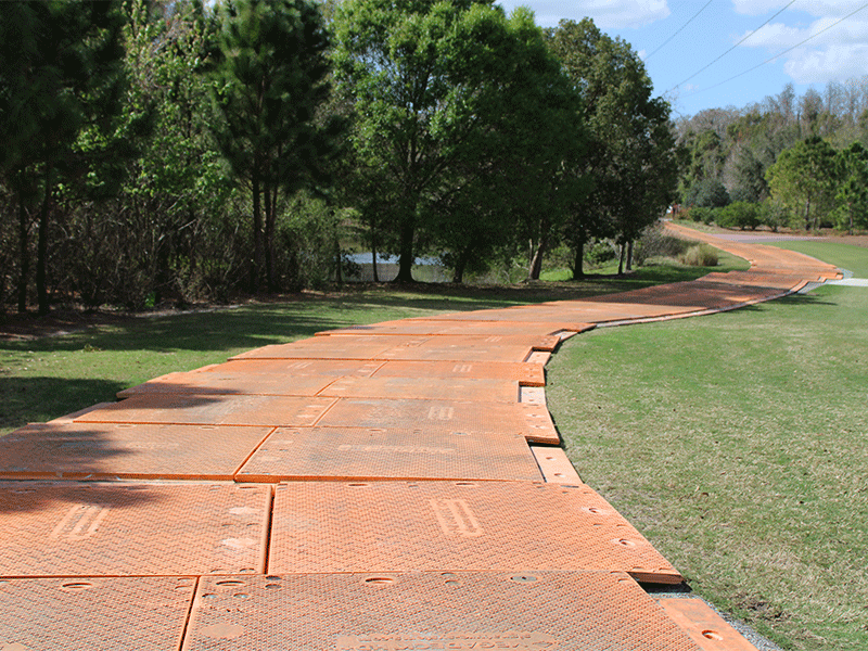 image of composite matting providing a temporary roadway across a grass field